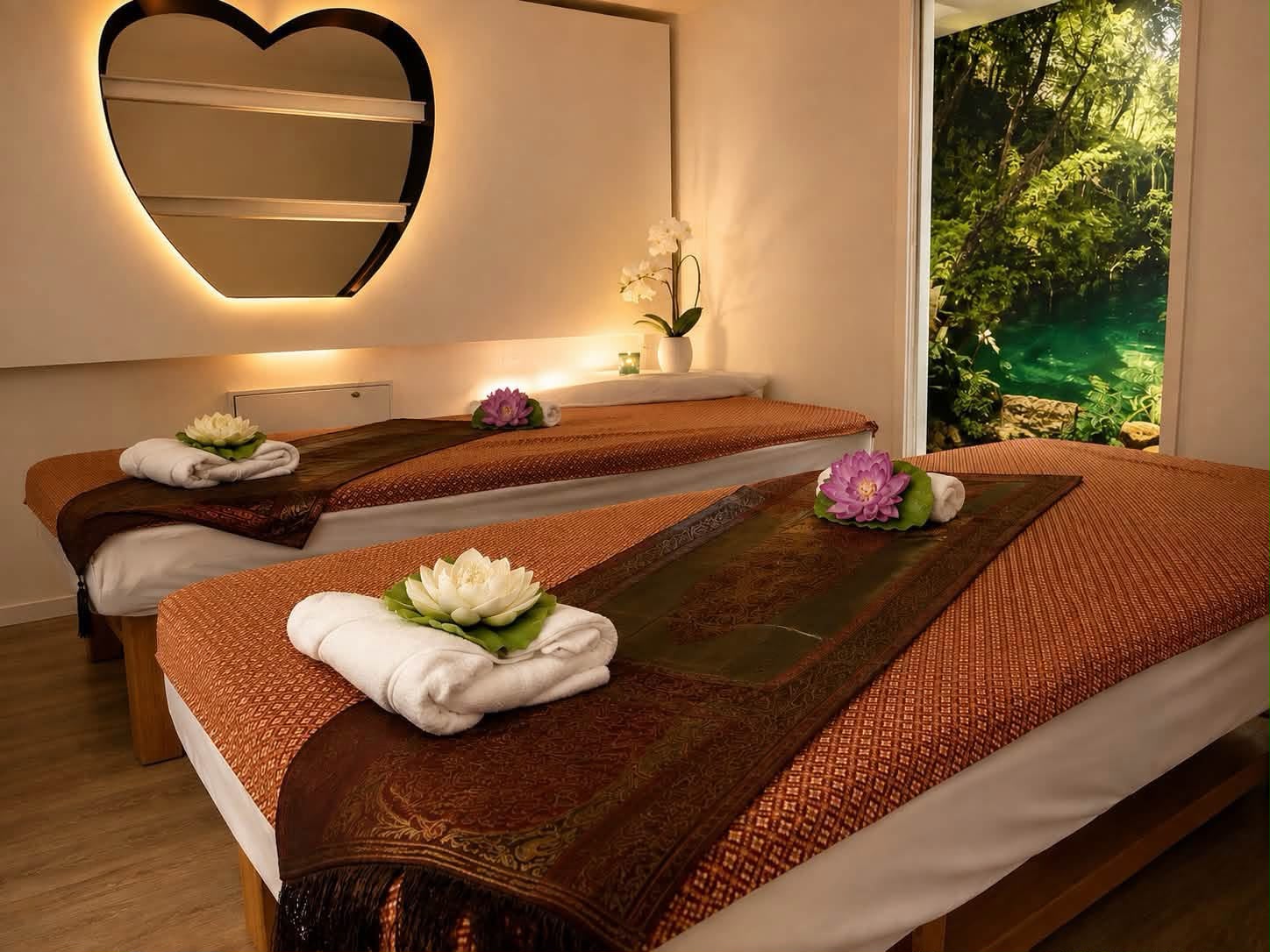 Gemütlicher Massageraum mit zwei Liegen, Handtüchern und stimmungsvollem Licht